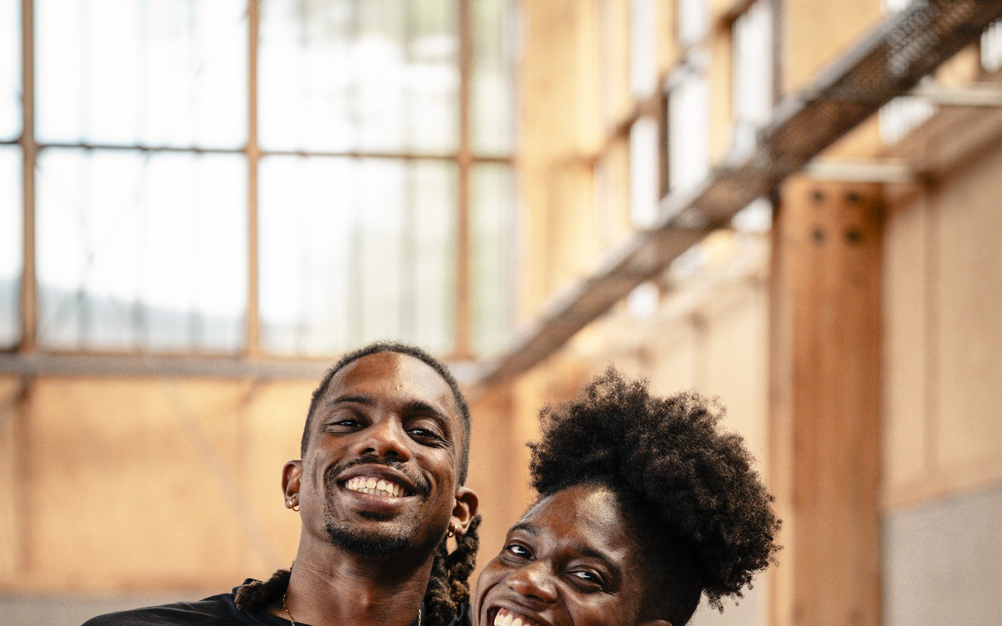 Deux personnes sourient ensemble dans une salle d’athlétisme